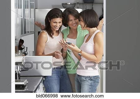 Stock Photo - Daughters explaining cell phone to mother. Fotosearch