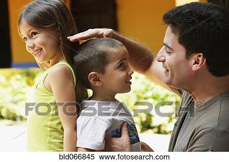 Stock Photography - Father comparing children’s height. Fotosearch