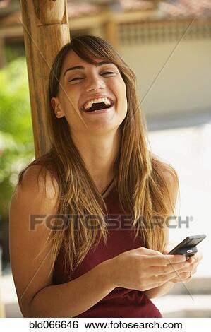 Stock Photograph - Happy woman texting on cell phone. Fotosearch