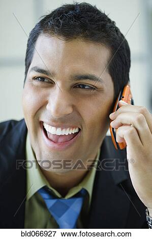 Stock Photo - Hispanic businessman talking on cell phone. Fotosearch