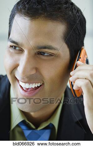 Stock Photograph - Hispanic businessman talking on cell phone. Fotosearch