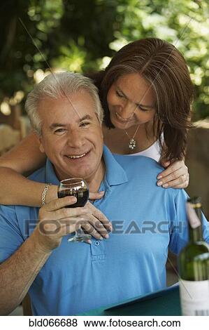 Stock Photo - Hispanic couple drinking red wine in cafe. Fotosearch