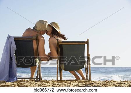 Stock Image - Hispanic couple kissing on beach. Fotosearch