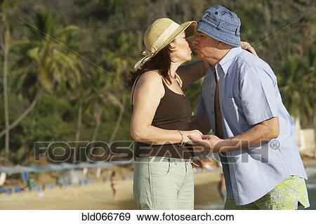 Stock Photo - Hispanic couple kissing on beach. Fotosearch