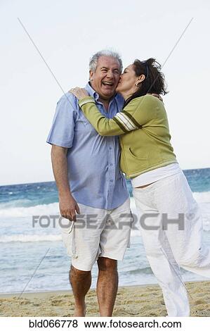 Stock Photo - Hispanic couple kissing on beach. Fotosearch