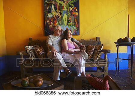 Hispanic couple sitting in living room View Large Photo Image Stock Photograph - Hispanic couple sitting in living room. Fotosearch