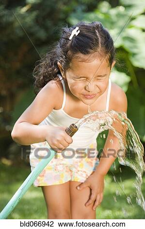 Hispanic girl drinking from hose View Large Photo Image Stock Image - Hispanic girl drinking from hose. Fotosearch