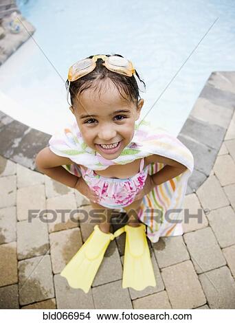 Picture - Hispanic girl standing at poolside in flippers. Fotosearch