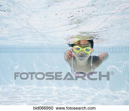 Stock Image - Hispanic girl swimming in pool. Fotosearch