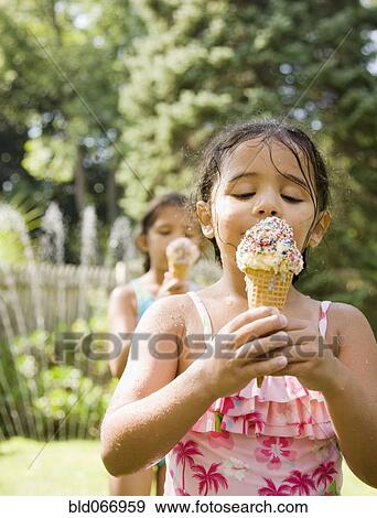 Hispanic girls eating ice cream cones View Large Photo Image Stock Photo - Hispanic girls eating ice cream cones. Fotosearch