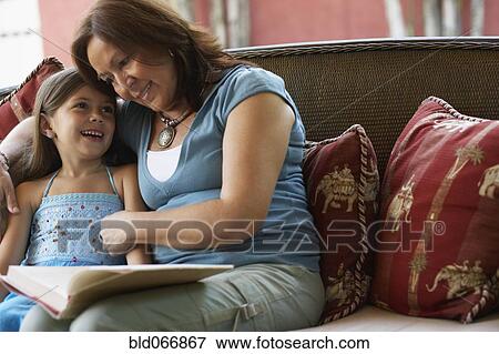 Hispanic grandmother reading to granddaughter View Large Photo Image Stock Photo - Hispanic grandmother reading to granddaughter. Fotosearch