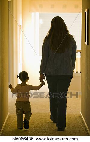Hispanic mother and daughter walking in hallway View Large Photo Image Stock Photograph - Hispanic mother and daughter walking in hallway. Fotosearch
