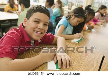 Picture - Hispanic school boy making name card. Fotosearch