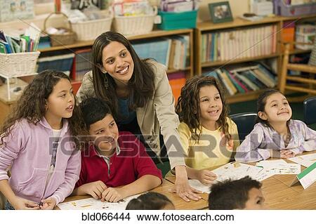 Picture - Hispanic school teacher helping students. Fotosearch