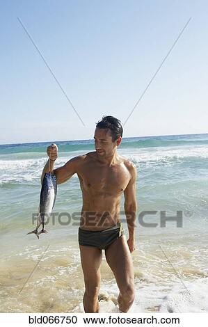 Man carrying fish out of ocean View Large Photo Image Stock Image - Man carrying fish out of ocean. Fotosearch
