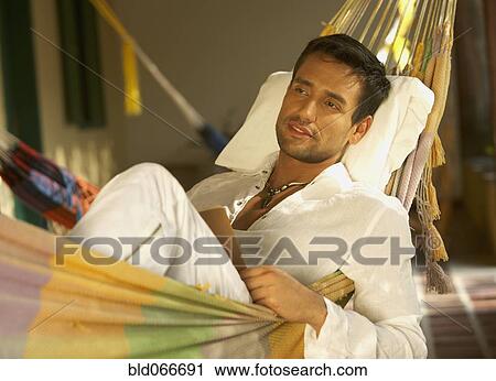 Stock Image - Man laying in hammock. Fotosearch