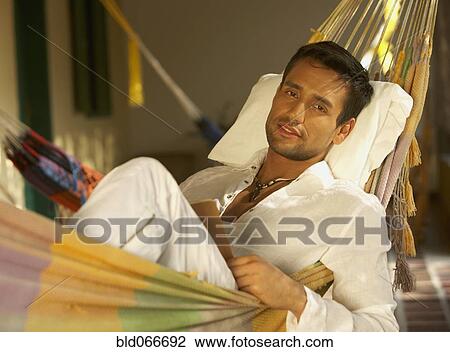 Stock Image - Man laying in hammock. Fotosearch