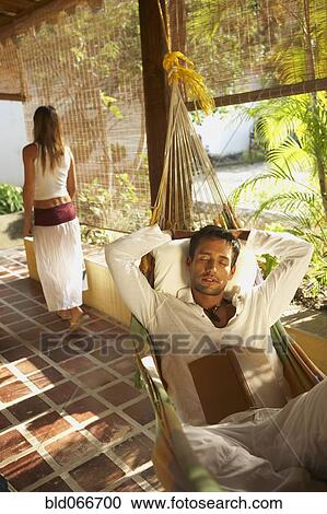 Stock Image - Man laying in hammock. Fotosearch