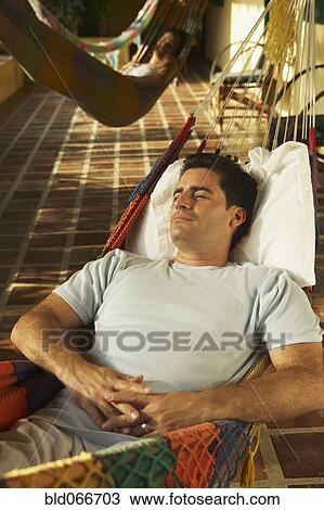 Stock Image - Man laying in hammock. Fotosearch