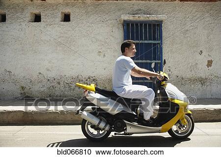 Man riding scooter View Large Photo Image Stock Image - Man riding scooter. Fotosearch