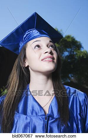 Stock Photo - Mixed race girl in graduation cap and gown. Fotosearch