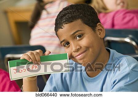 Mixed race school boy holding name card View Large Photo Image Stock Image - Mixed race school boy holding name card. Fotosearch