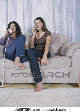 Picture - Mother and adult daughter using different phones. Fotosearch