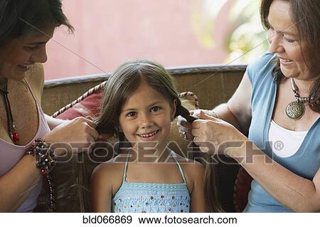 Mother and grandmother braiding girl’s hair View Large Photo Image Stock Photo - Mother and grandmother braiding girl’s hair. Fotosearch