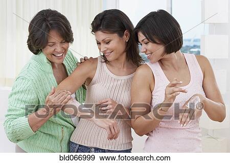 Mother and sisters applying lotion to skin View Large Photo Image Stock Photo - Mother and sisters applying lotion to skin. Fotosearch