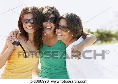Stock Photograph - Mother and sisters hugging. Fotosearch