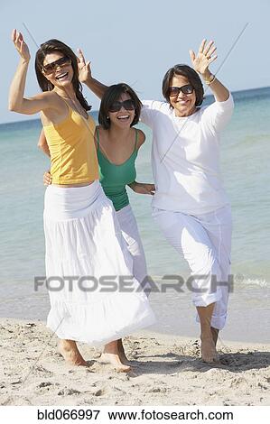 Stock Photo - Mother and sisters playing on beach. Fotosearch