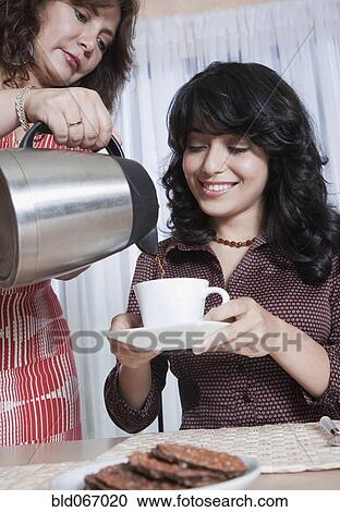 Mother serving daughter coffee and cookies View Large Photo Image Stock Image - Mother serving daughter coffee and cookies. Fotosearch