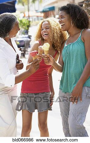 Stock Photograph - Multi-generational women eating ice cream cones. Fotosearch