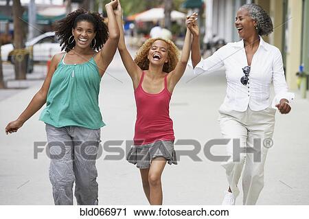 Stock Image - Multi-generational women holding hands. Fotosearch