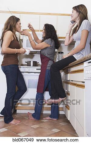 Stock Photo - Multi-generational women in kitchen. Fotosearch