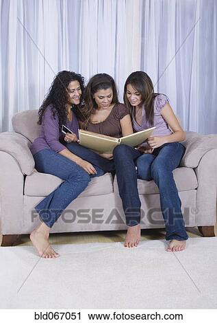Multi-generational women looking at photo album View Large Photo Image Stock Image - Multi-generational women looking at photo album. Fotosearch