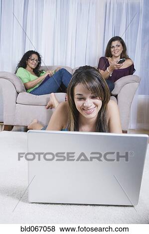 Multi-generational women using different forms of entertainment View Large Photo Image Stock Photo - Multi-generational women using different forms of entertainment. Fotosearch