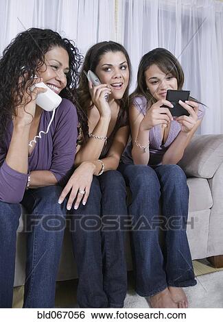 Stock Photograph - Multi-generational women using different phones. Fotosearch