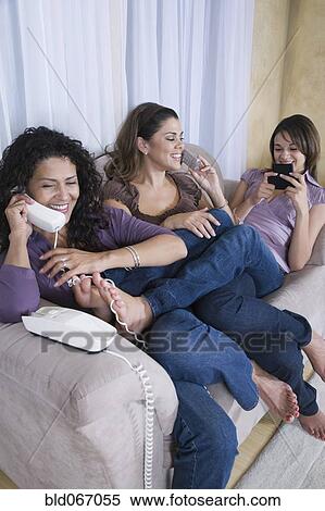 Stock Photography - Multi-generational women using different phones. Fotosearch