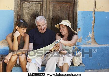 Stock Image - People looking at map. Fotosearch