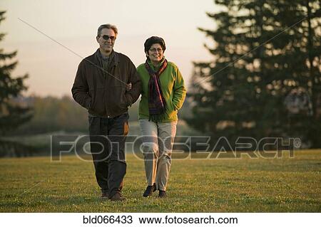 Stock Image - Peruvian couple walking in park. Fotosearch