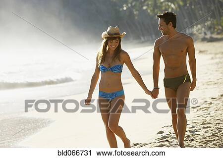 Smiling couple walking on beach View Large Photo Image Stock Image - Smiling couple walking on beach. Fotosearch