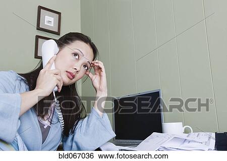 Stock Photograph - Stressed woman talking on telephone. Fotosearch