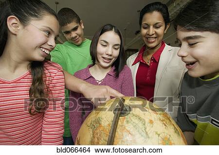 Students and teacher looking at globe View Large Photo Image Picture - Students and teacher looking at globe. Fotosearch