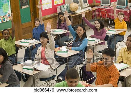 Stock Photograph - Students raising hands in classroom. Fotosearch