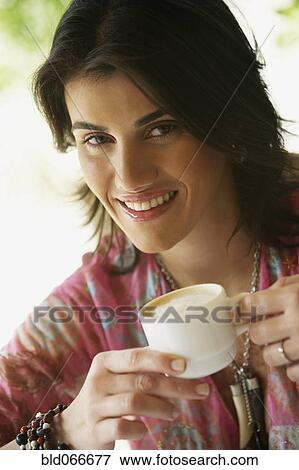 Stock Photo - Woman drinking coffee in cafe. Fotosearch