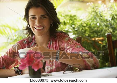 Stock Photography - Woman drinking coffee in cafe. Fotosearch