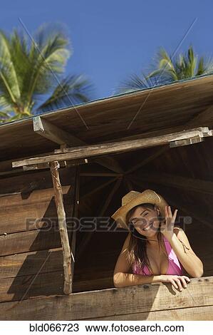 Stock Image - Woman in lifeguard tower at beach. Fotosearch