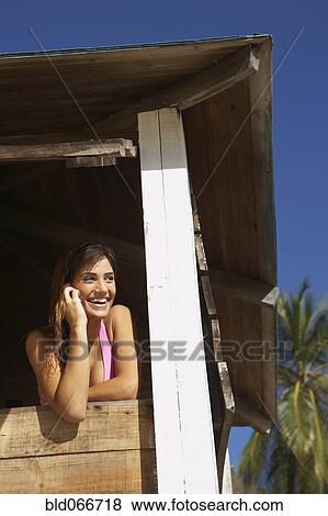 Stock Photo - Woman in lifeguard tower at beach. Fotosearch