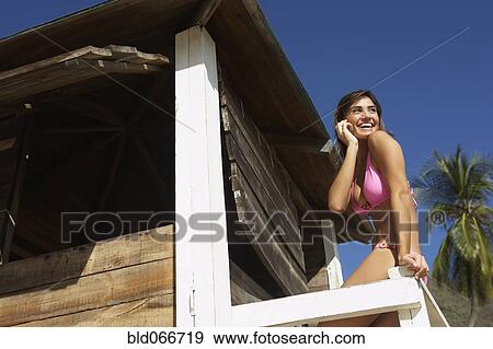Stock Photo - Woman in lifeguard tower at beach. Fotosearch